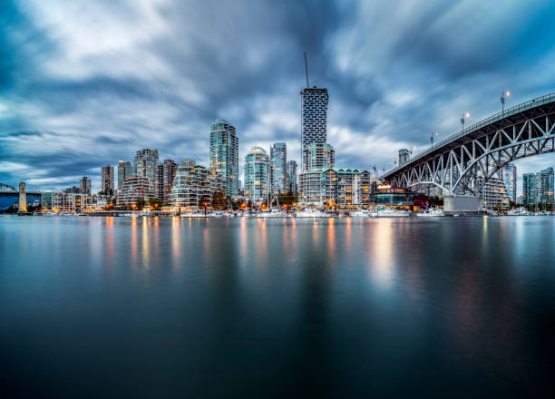 Skyline sul lungomare di Vancouver con ponte di Granville sotto nuvole tempestose - foto stock
