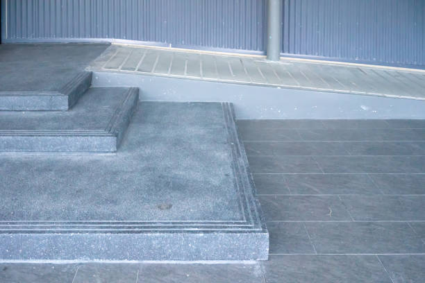 istock Ramped access, using wheelchair ramp for disabled people. Concrete ramp pathway. 1064462562