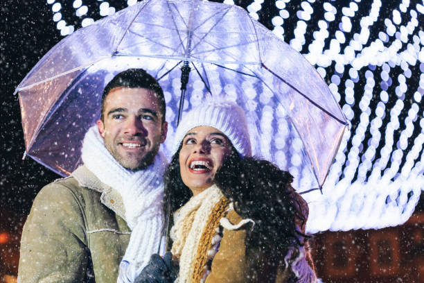 istock Couple holding umbrella and having fun at night 1064464464