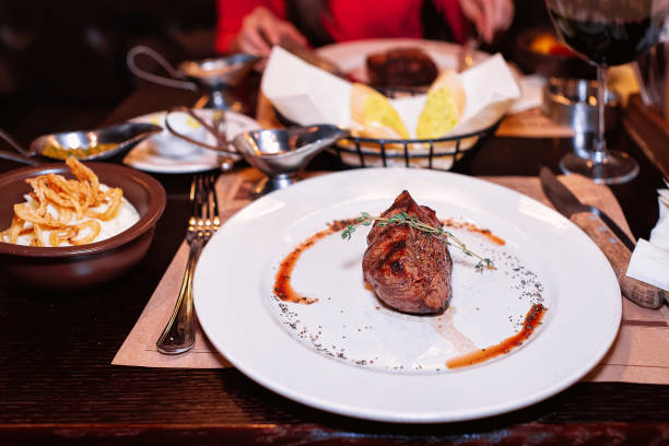 istock Medium rare Steak with pepper sauce on white plate 1064470070