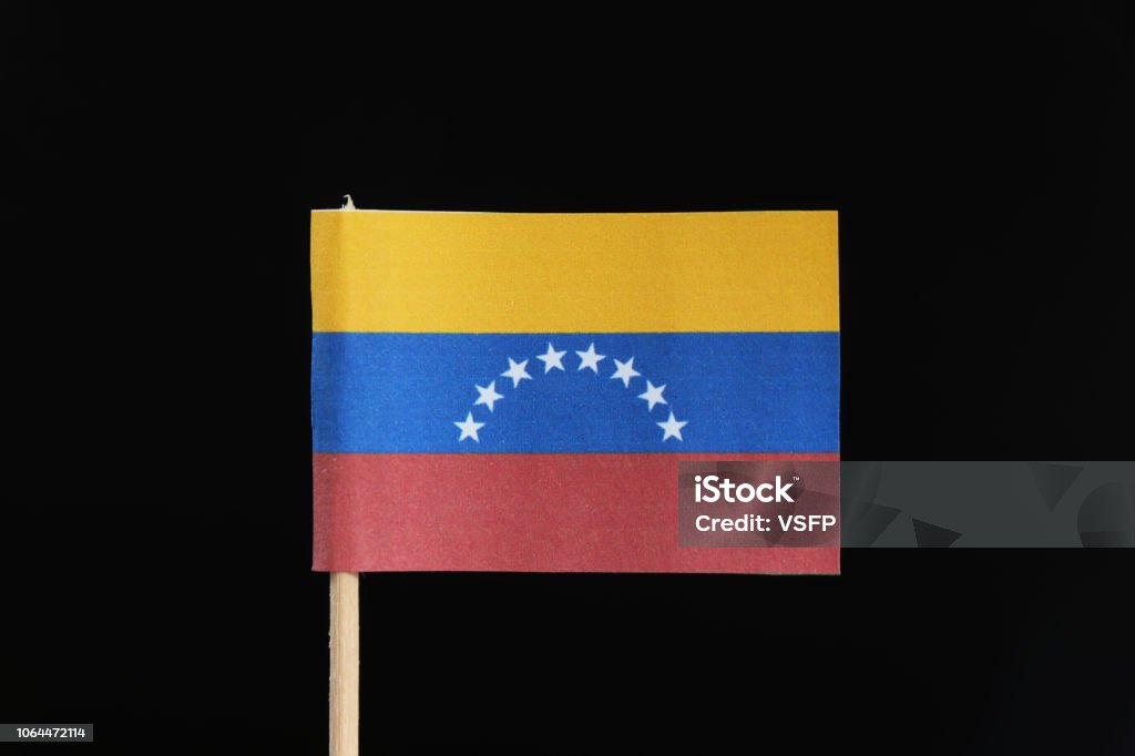 A official and original flag of Venezuela  on toothpick on black background. A horizontal tricolor of yellow, blue and red with an arc of eight white five pointed stars centered on the blue band A official and original flag of Venezuela  on toothpick on black background. A horizontal tricolor of yellow, blue and red with an arc of eight white five pointed stars centered on the blue band. Banner - Sign Stock Photo