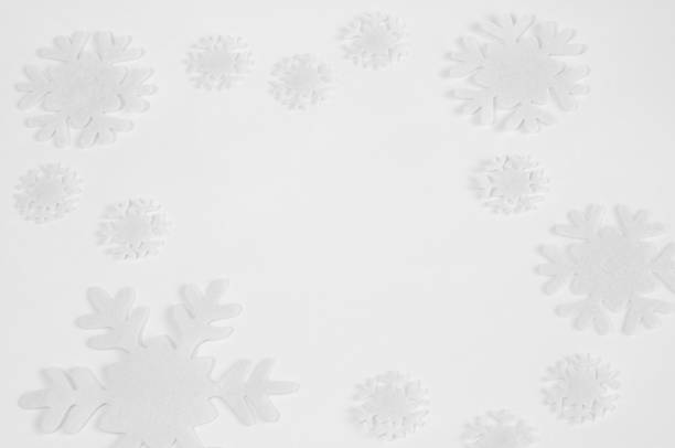 istock White felt snowflakes on a white background. 1064472648