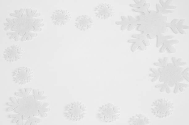 istock White felt snowflakes on a white background. 1064472658