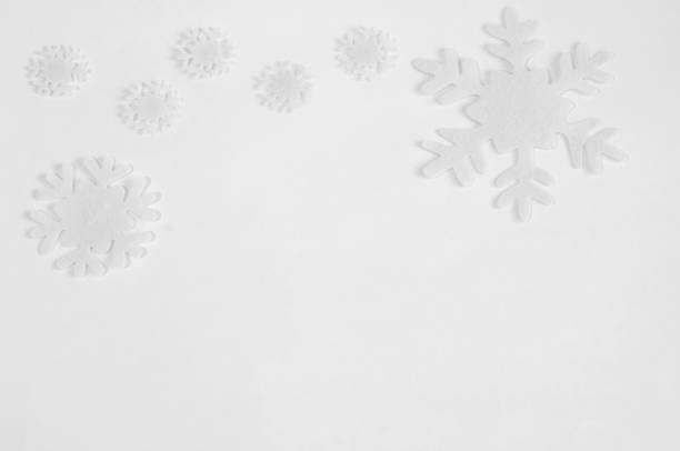 istock White felt snowflakes on a white background. 1064472660