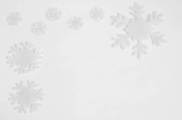 istock White felt snowflakes on a white background. 1064472670