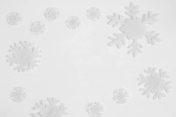 istock White felt snowflakes on a white background. 1064472684