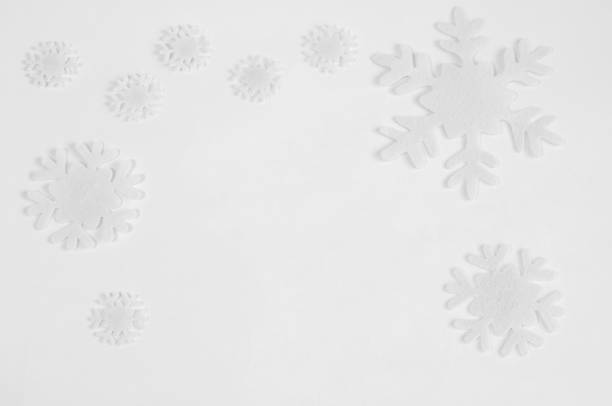 istock White felt snowflakes on a white background. 1064472688
