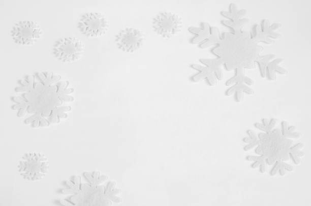 istock White felt snowflakes on a white background. 1064472692