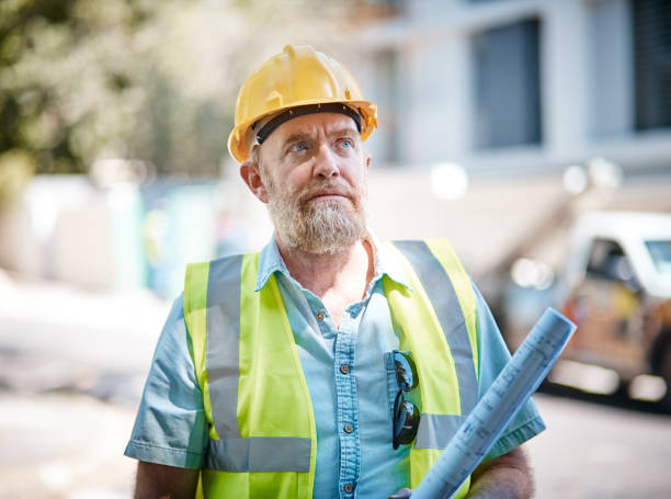 istock Construction professional in hard hat and reflective clothing eyes building 1064475286