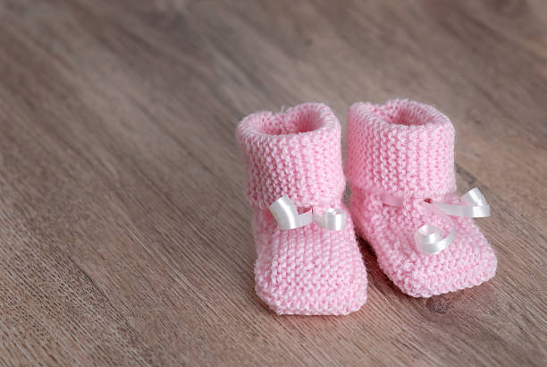istock pink baby booties on wooden surface 106447643