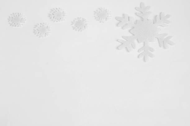 istock White felt snowflakes on a white background. 1064477766