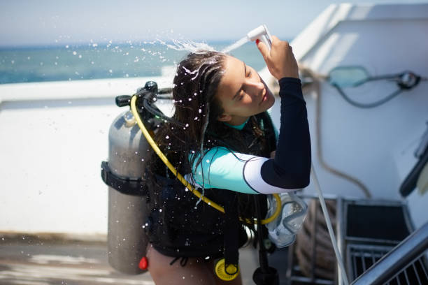 istock Scuba diver girl showering herself on a boat deck 1064480498