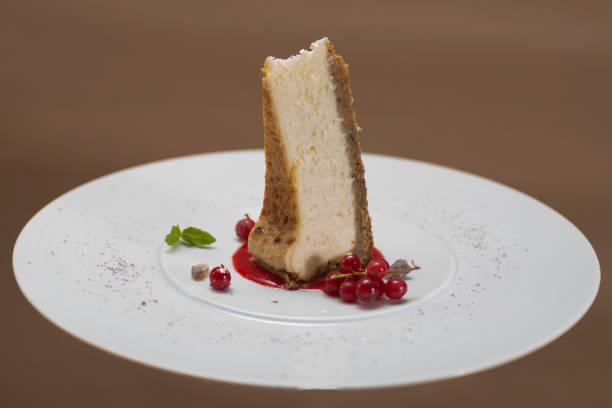 istock Slice cheesecake with forest fruits – red currants,  mint and gold leaf on white plate,  brown background 1064481848