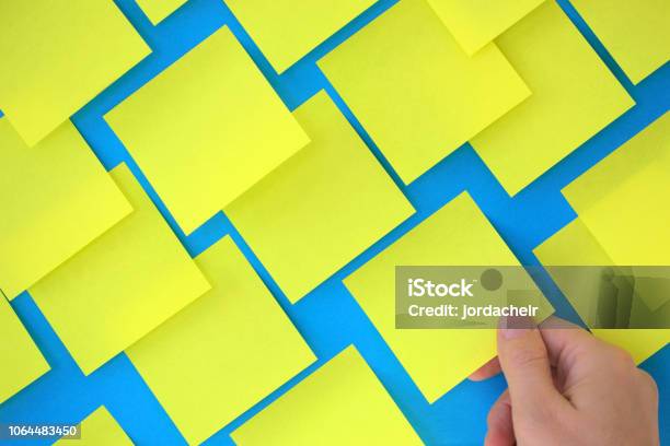 Hand Holding Postit Note On Blue Board Stock Photo - Download Image Now ...