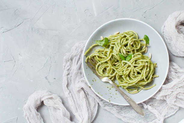 istock Spaghetti pasta with pesto sauce 1064483524