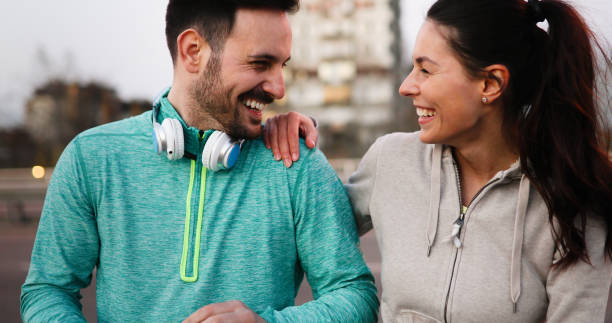 istock Young attractive couple running outside on sunny day 1064483698