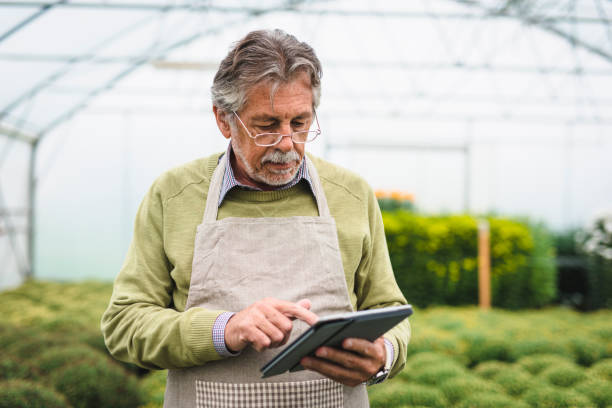 istock Senior man using a digital tablet in the greenhouse 1064483868