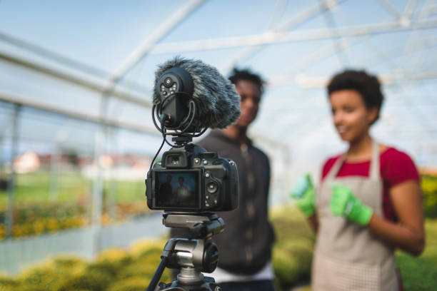 istock Two young African Americans vlogging in the greenhouse 1064483952