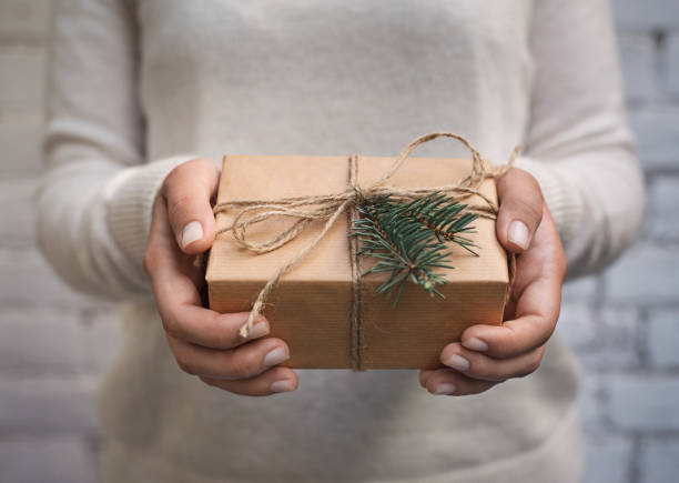 istock Woman holding craft paper gift box for present 1064504682