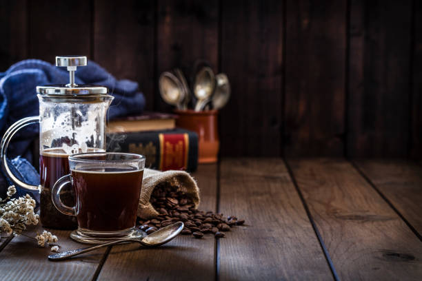 istock Coffee backgrounds: coffee cup and coffee french press on rustic wooden table with copy space 1064506784