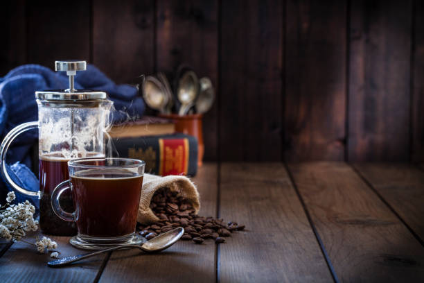 istock Coffee backgrounds: coffee cup and coffee french press on rustic wooden table with copy space 1064506804