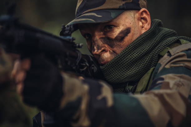 istock Soldier shooting a weapon in forest 1064510914