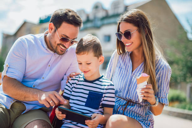 istock Smiling parents and little boy with tablet pc outdoor 1064511222