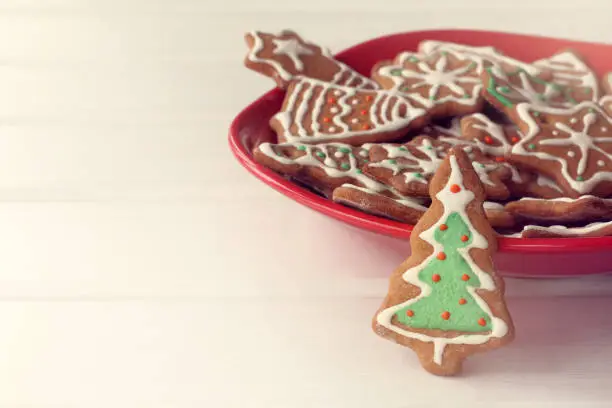festive evergreen tree decorated with icing on the background of a plate with curly pastry