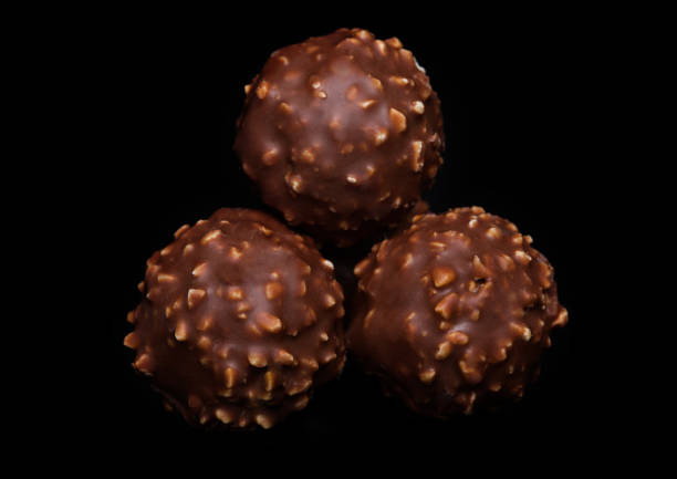 istock Luxury chocolate candies with hazelnuts and cocoa cream on black background. 1064514514