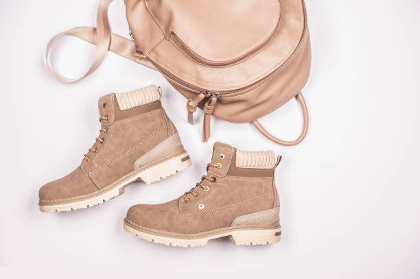 Pairs of a beige suede shoes on a sand. Girl in a pairs of a shoes.