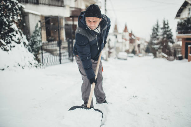 istock Senior man cleans sidewalk in winter 1064519412