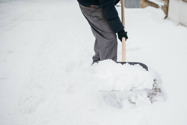 istock Man with snow shovel cleans sidewalk 1064519676