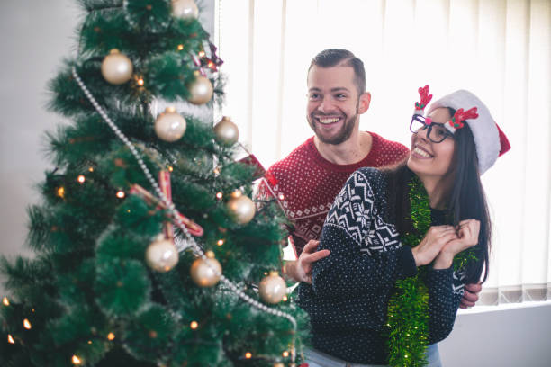 istock Cute, young couple decorating a Christmas tree 1064530686