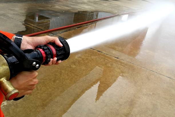 spraying water for test fire fighting system - fire hose imagens e fotografias de stock