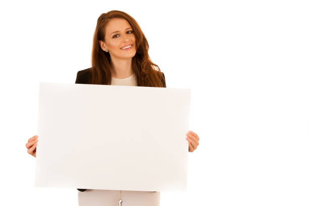 istock attractive business woman holding white banner with copy spave for additional text or graphic isolated over white 1064535564