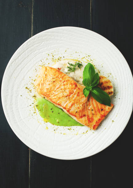 istock Baked salmon with sauce and spices on a white plate 1064536860