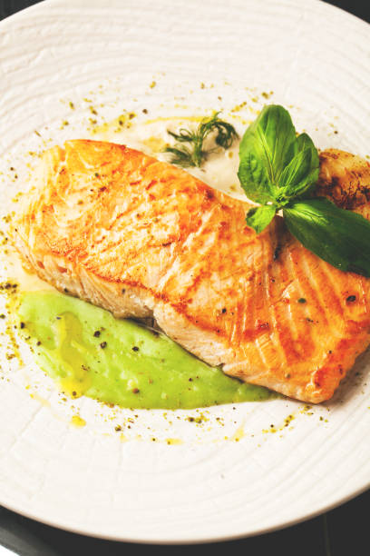 istock Baked salmon with sauce and spices on a white plate 1064536942