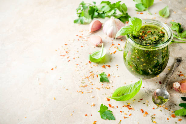 Argentinian Chimichurri sauce Argentinian traditional food, raw homemade green Chimichurri salsa or sauce woth parsley, garlic, basil leaves, hot pepper and spices, light stone table copy space chimichurri stock pictures, royalty-free photos & images