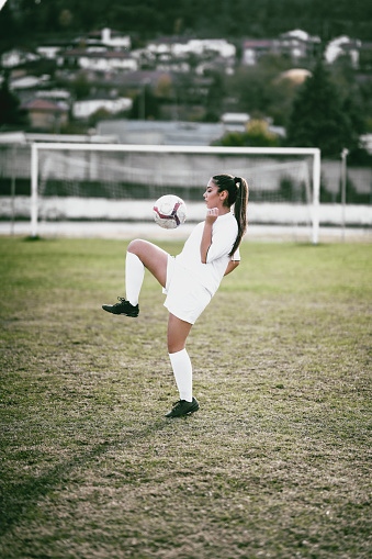 Cute Female Football Player Juggling A Ball With On Her Knee