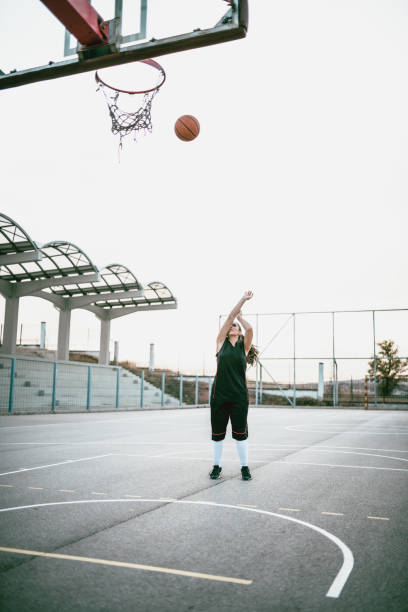 istock Female Basketball Player Exercising Proper Shooting Technique 1064546902