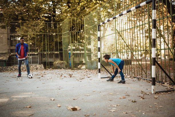 istock Father and son playing soccer outdoors 1064547048