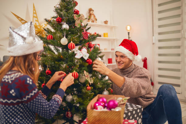 istock Happy couple decorating tree for New Year's / Christmas eve. 1064548032