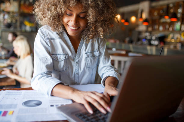 istock Young woman typing on laptop in cafe 1064550544