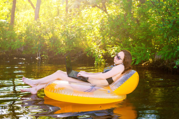 istock Woman freelancer working on a laptop sitting in an inflatable ring, remote work. 1064550848
