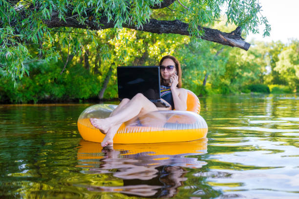 istock Woman freelancer working on a laptop sitting in an inflatable ring, remote work. 1064550882