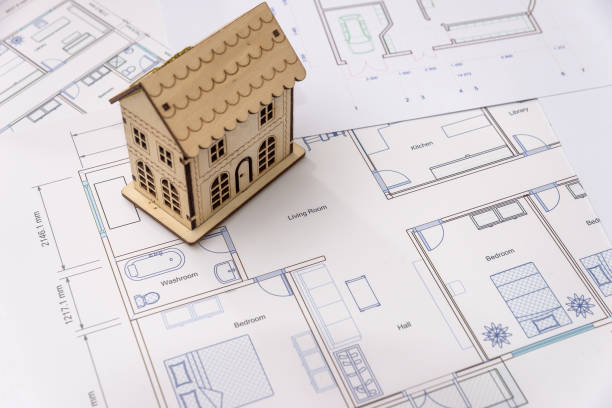 istock Wooden house model on house plan, close up 1064553108