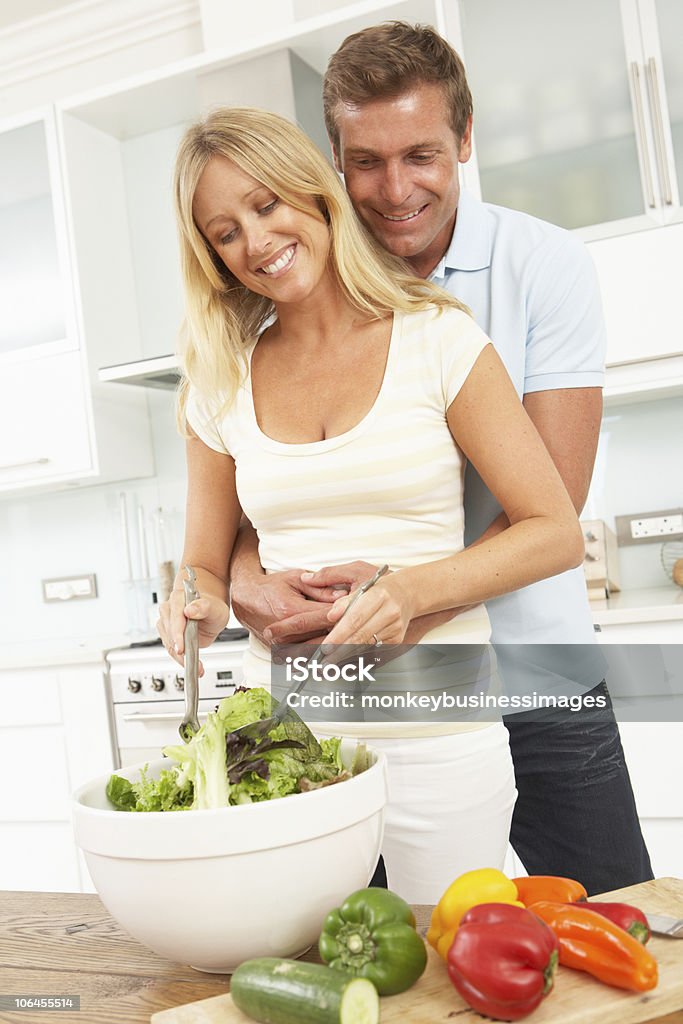 Casal preparando uma salada na cozinha moderna - Foto de stock de Comer royalty-free