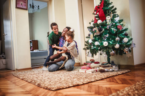 istock Father playing with kids next to the Christmas tree 1064555674