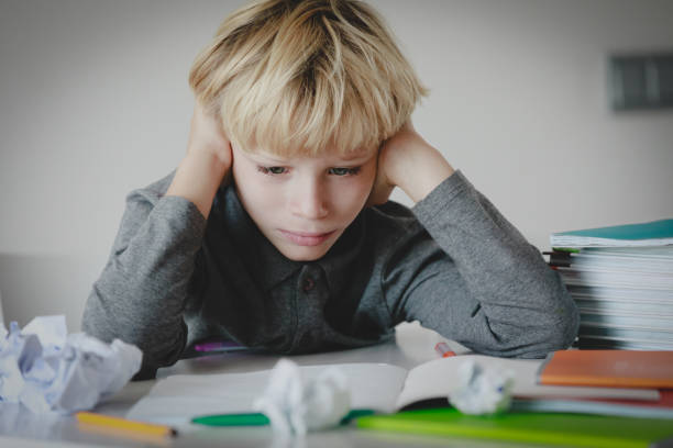 istock little boy tired stressed of reading, doing homework 1064555766