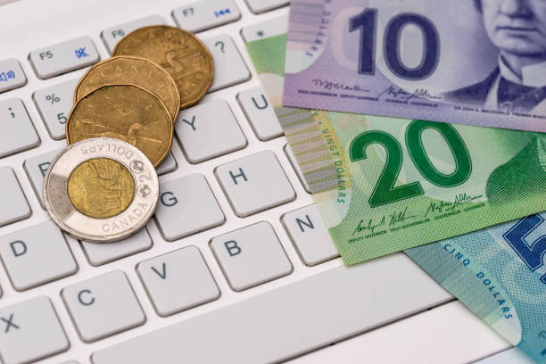 Canadian dollar with laptop  - business concept